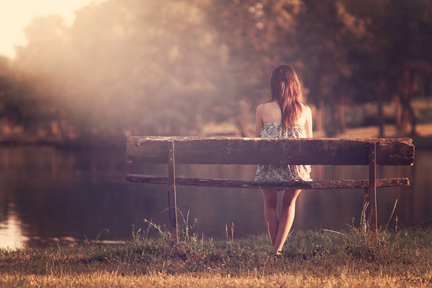 Chica sentada en un banco
 - Foto, Imagen