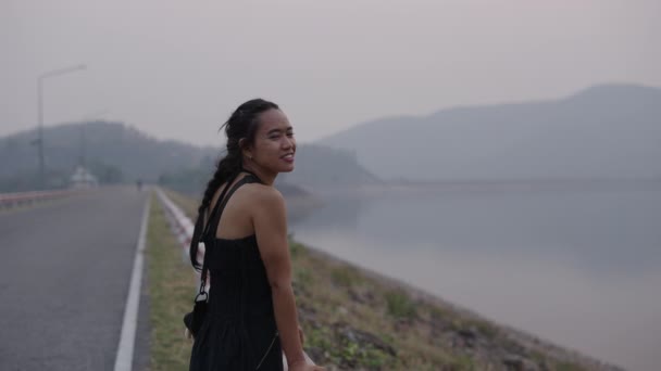 Ασιάτισσα που κοιτάζει μια λίμνη ανάμεσα στα βουνά - Wanderer - Πλάνα, βίντεο