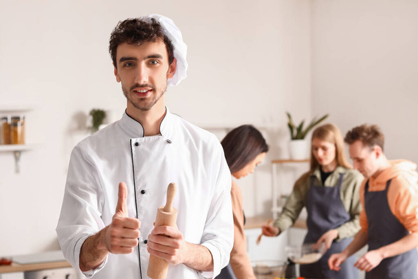 İtalyan aşçı mutfakta aşçılık kursunda parmak kaldırıyor. - Fotoğraf, Görsel