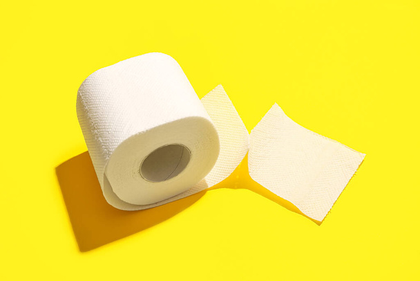рулон туалетной бумаги на желтом фоне - Фото, изображение