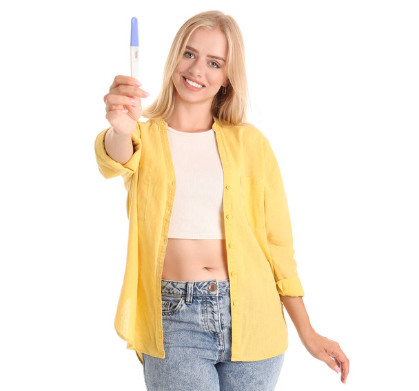 Счастливая красивая молодая женщина с тестом на беременность изолированы на белом фоне - Фото, изображение