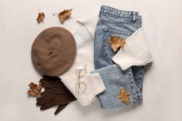 Composición con ropa femenina con estilo, accesorios y hojas de otoño sobre fondo claro - Foto, Imagen