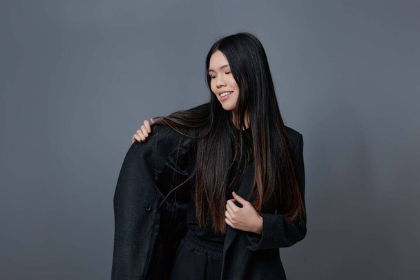 Nainen aasialainen malli kauneus syksy syksy muoti takki hiukset elämäntapa vaatteet hymy tyylikäs studio tyttö brunette kaunis muotokuva söpö talvi harmaa trendikäs glamouria - Valokuva, kuva