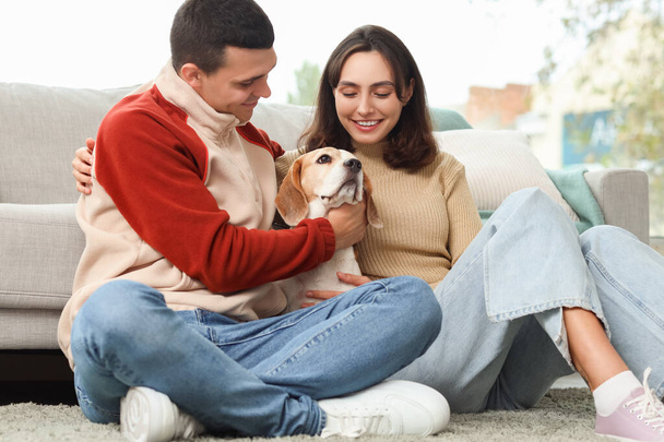 Mladý pár s roztomilým bíglí pes doma - Fotografie, Obrázek