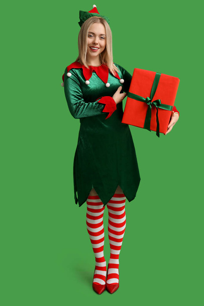 Mladá žena v elf kostým s vánoční dárková krabice na zeleném pozadí - Fotografie, Obrázek