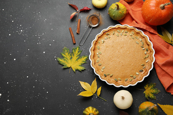 Composition d'automne avec une délicieuse tarte à la citrouille sur fond noir - Photo, image