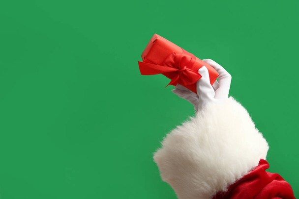 Joulupukki punaisella lahjapakkauksella vihreällä taustalla - Valokuva, kuva
