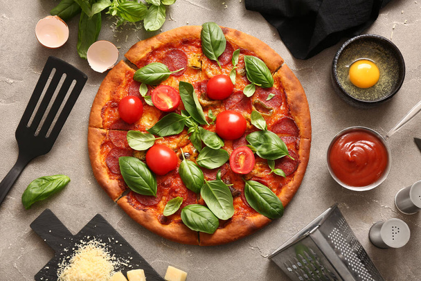 Délicieuse pizza Pepperoni aux tomates et basilic sur fond gris - Photo, image