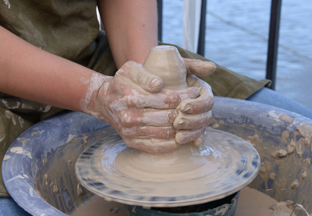 Učit házet kola. Potterova ruka opravuje ženy ty během tvarování jílu prázdné na hrnčířském kole. - Fotografie, Obrázek