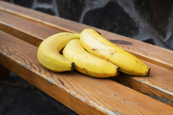 racimo de plátano amarillo maduro en una superficie de madera. - Foto, Imagen