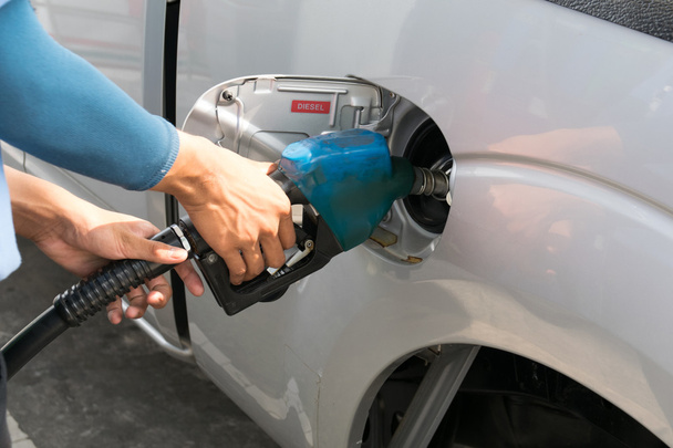 Los hombres sostienen la boquilla de combustible para agregar combustible en el coche en la gasolinera - Foto, imagen