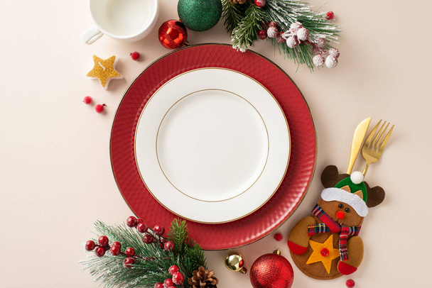 Gyermek újévi éttermi asztal elrendezése: felülnézet elragadó kialakítású tányérok, arany edények vicces tartóban, baubles, gyertya, fagyos fenyőágak, fagyöngy puha bézs háttérrel - Fotó, kép