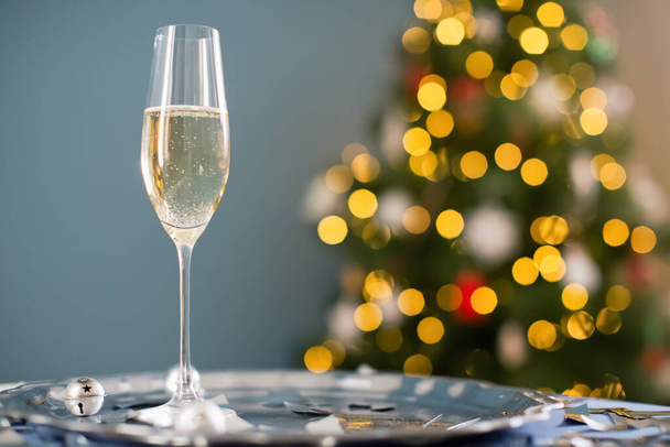 Vintage stříbrný podnos se sklenkou šampaňského, vánoční zvony, hořící perličky a stříbrné konfety na vánoční stromeček pozadí s kopírovacím prostorem - Fotografie, Obrázek