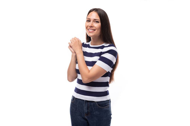 slank jong Kaukasisch brunette promotor vrouw in een gestreept zwart-wit t-shirt op een witte achtergrond. - Foto, afbeelding