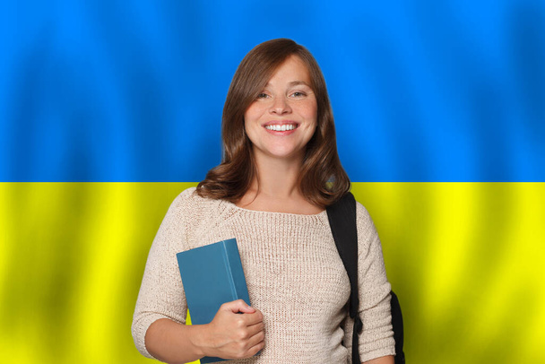 Donna felice studente sullo sfondo bandiera ucraina. Viaggio, istruzione e imparare la lingua in Ucraina concetto - Foto, immagini