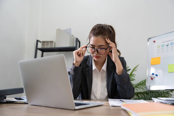 Бізнес азіатки стрес під час роботи на ноутбуці, втомлена ділова жінка з головним болем в офісі, відчуває себе хворим на роботі. - Фото, зображення