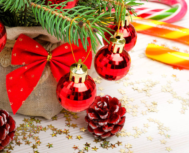 New Year card, Christmas tree branches, balls, gift, cones and bow. Festive mood of Christmas and New Year. - Photo, Image