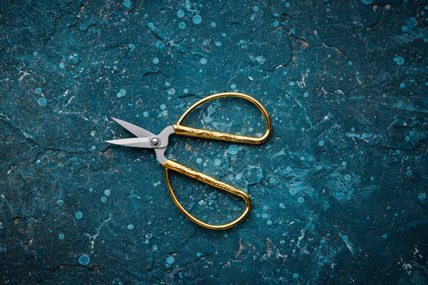 Old vintage rusty scissors isolated over vintage blue backdrop texture dark background - Photo, Image