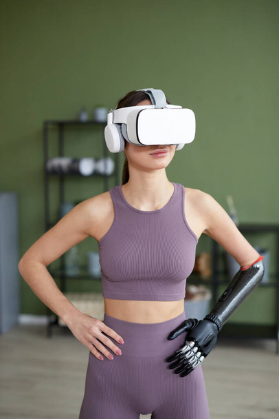 Молода дівчина в спортивному одязі робить вправи вдома у окулярах віртуальної реальності - Фото, зображення