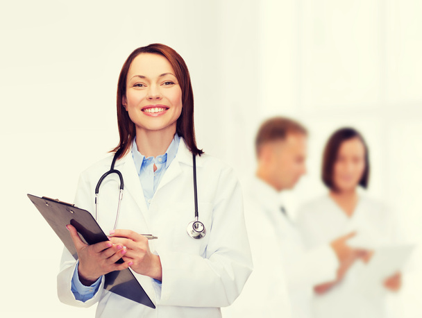 smiling female doctor with clipboard - Zdjęcie, obraz