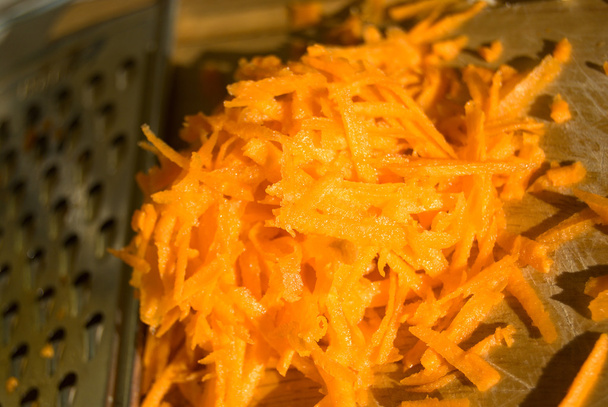Montón de zanahoria en rodajas en rallador
  - Foto, imagen