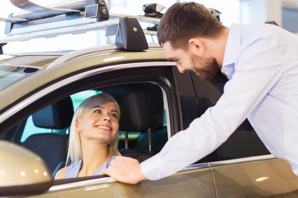 happy couple buying car in auto show or salon - 写真・画像