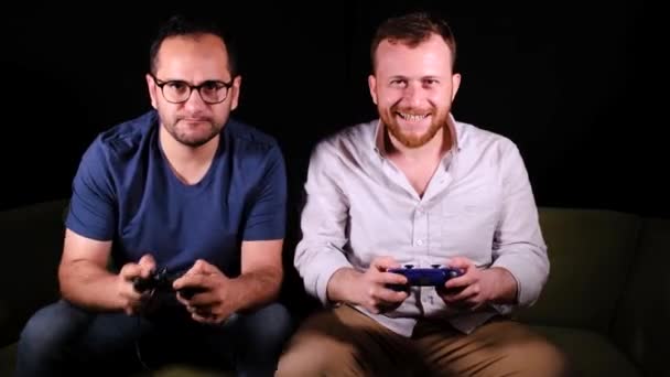 Los hombres están jugando emocionados con joysticks - Imágenes, Vídeo