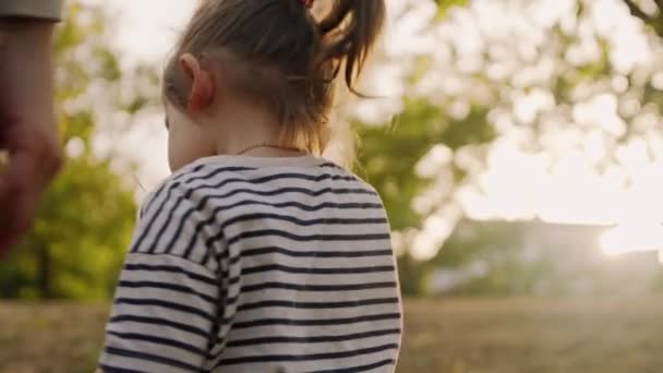 Annesiyle küçük şirin bir kız, açık havada. Sonbahar parkında yürüyen mutlu çocuk. Mutlu aile kavramı - Video, Çekim