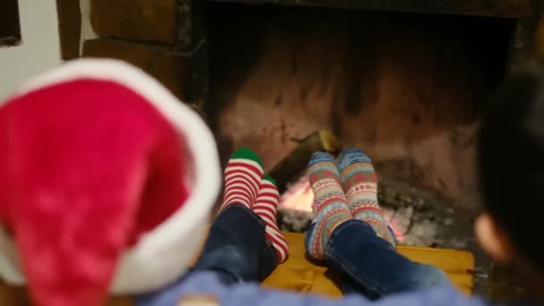 dzieci świętujące Boże Narodzenie przy kominku - Materiał filmowy, wideo