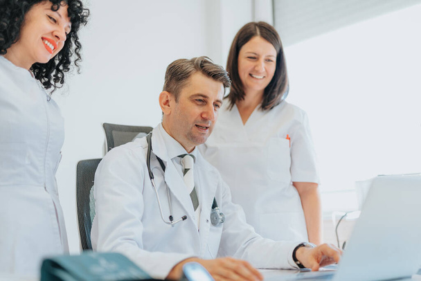 Doctor and nurses discussing diagnostic test results, providing consultation and explaining health problems. Cardiogram tests and radiology findings reviewed for accurate diagnosis and treatment. - Photo, Image