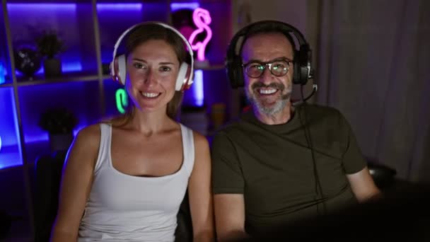 Vader en dochter samen in gaming glorie, twee lachende gamers genieten van video game overwinning thuis gaming kamer - Video
