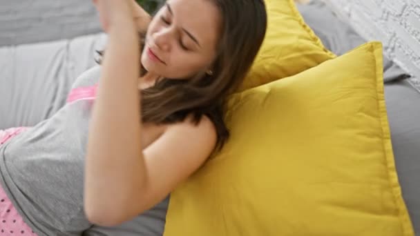 Kaunis nuori latino nainen makaa mukavasti makuuhuoneessaan, valmistautuu putoamaan syvään uneen uuvuttavan päivän jälkeen. - Materiaali, video