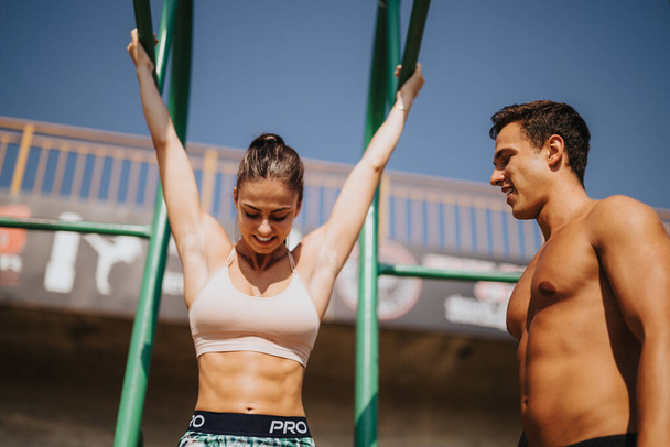 A motivated couple embraces a challenging outdoor workout, showcasing their strength and persistence. The sunny day and natural environment create a refreshing setting for their fitness routine. - Фото, изображение