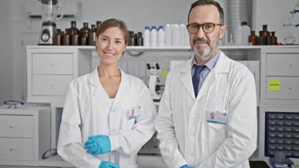 Dois cientistas sorridentes trabalhando juntos no laboratório, de pé de braços cruzados, maravilhados com seu avanço médico - Filmagem, Vídeo