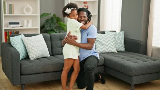 Afro-Amerikaanse vader en dochter glimlachend zelfverzekerd knuffelen elkaar staan thuis - Video