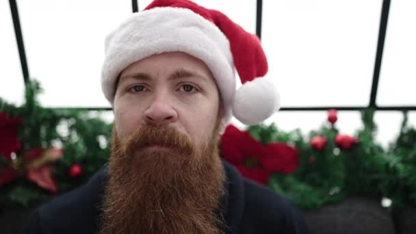 Man in Claus hat with a beard and holding a credit card - Footage, Video