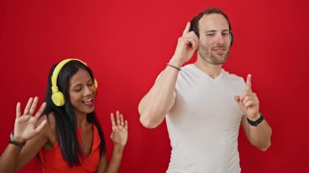 Beau couple écoutant de la musique et dansant sur fond rouge isolé - Séquence, vidéo