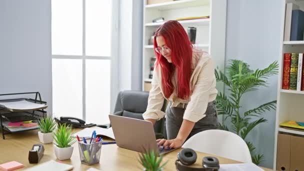 Впевнена руда бізнес-леді, що святкує успіх роботи на офісному столі, радісний молодий менеджер тріумфально жести успіх на ноутбуці - Кадри, відео