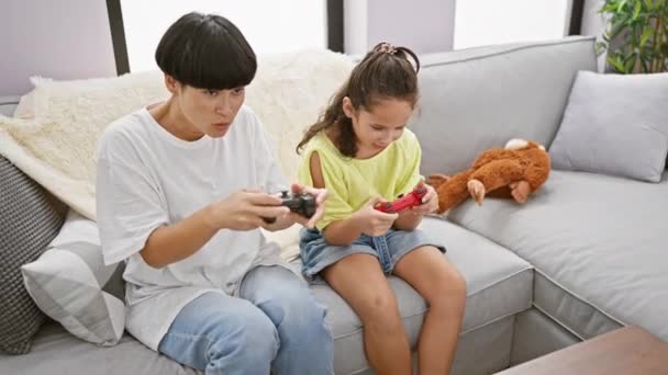 Στην άνεση του σπιτιού, μητέρα και κόρη, γιορτάζει χαρούμενα, ενώ gaming στον καναπέ - Πλάνα, βίντεο