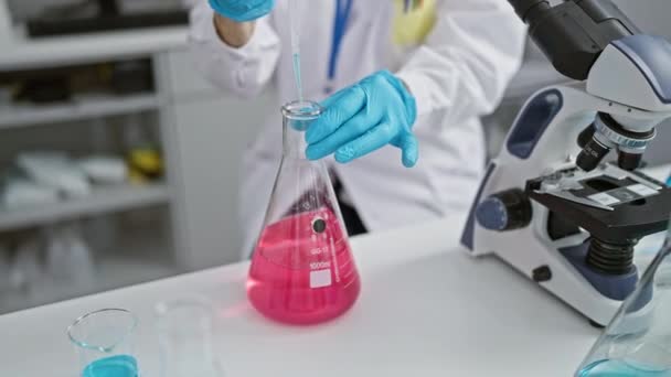 Die Hände der Wissenschaftlerin gießen akribisch Flüssigkeit in ein Reagenzglas für Experimente im Labor und verkörpern das Engagement reifer Frauen in der Welt der medizinischen Forschung - Filmmaterial, Video