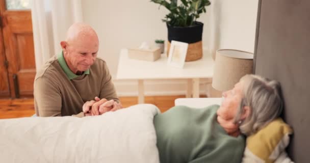 Κρεβάτι, άρρωστοι και ηλικιωμένοι ζευγάρι για φροντίδα κρατώντας τα χέρια για την υποστήριξη, συγκόλληση και ενσυναίσθηση στο σπίτι μαζί. Συνταξιούχος, γάμος και ηλικιωμένοι άνδρες και γυναίκες στην κρεβατοκάμαρα για ασθένεια, θεραπεία και ανάρρωση. - Πλάνα, βίντεο