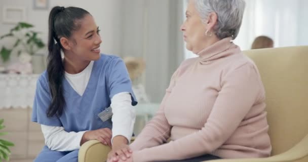 Conversación cogida de la mano y feliz con la enfermera con anciana en el sofá para la empatía, el apoyo y la confianza. Cuidado de la salud, jubilación y rehabilitación con paciente y cuidador en el hogar de ancianos para curación. - Metraje, vídeo
