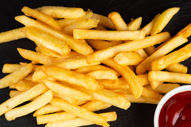 Batatas fritas ou batatas fritas com ketchup. Deliciosas batatas fritas em uma tábua de corte - Foto, Imagem
