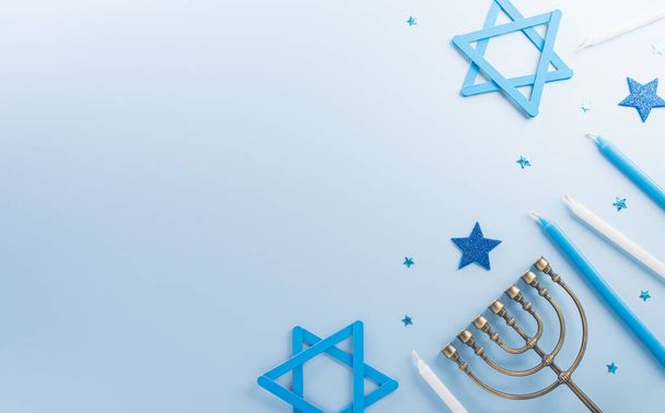 Jewish holiday Hanukkah concept. Top view of sweet donuts, menorah and candles on blue background. - Photo, Image