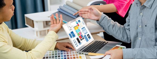 Καλλιεργημένη εικόνα της ομάδας εσωτερικών σχεδιαστών παρουσιάζει το χρώμα με τη χρήση έγχρωμων δειγμάτων, ενώ το laptop εμφανίζεται UI και UX σχέδια για κινητά app και ιστοσελίδα. Δημιουργικός σχεδιασμός και επιχειρηματική ιδέα. Ποικιλία. - Φωτογραφία, εικόνα