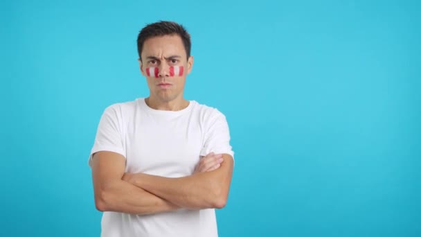 Βίντεο στο στούντιο με χρωμά ενός αξιοπρεπούς και σοβαρού άντρα με περουβιανή σημαία ζωγραφισμένη στο πρόσωπο κοιτάζοντας την κάμερα με αξιοπρέπεια - Πλάνα, βίντεο