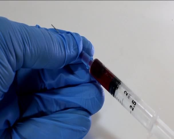 Doctor with glove and the syringe with blood sample - Video