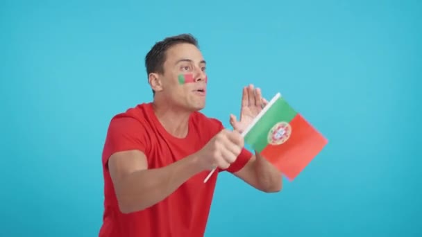 Video in studio with chroma of a man looking away waving a portuguese national flag, angry with a with a referees decision - Footage, Video