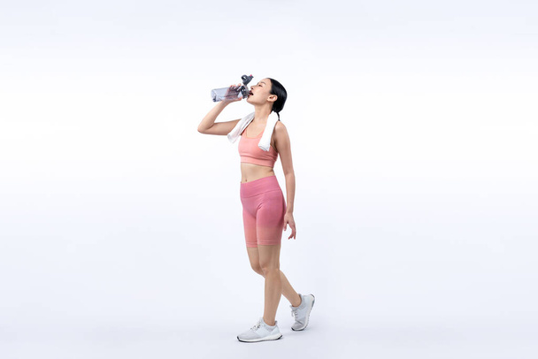 Αθλητική και σπορ Ασιάτισσα γυναίκα ξεκουράζεται και πίνει νερό μετά από εντατική προπόνηση καρδιο προπόνηση. Υγιής άσκηση και ταιριάζει το σώμα φροντίδα του τρόπου ζωής επιδίωξη στο στούντιο πυροβόλησε απομονωμένο υπόβαθρο. Έντονη - Φωτογραφία, εικόνα
