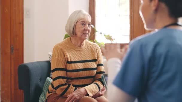 Zdravotní péče, konverzace a lékař se starší ženou v obývacím pokoji pro diagnózu nebo léčebný plán. Diskuse, ošetřovatelka a ošetřovatelka vysvětlující léčbu staršímu pacientovi v pečovatelském domě - Záběry, video